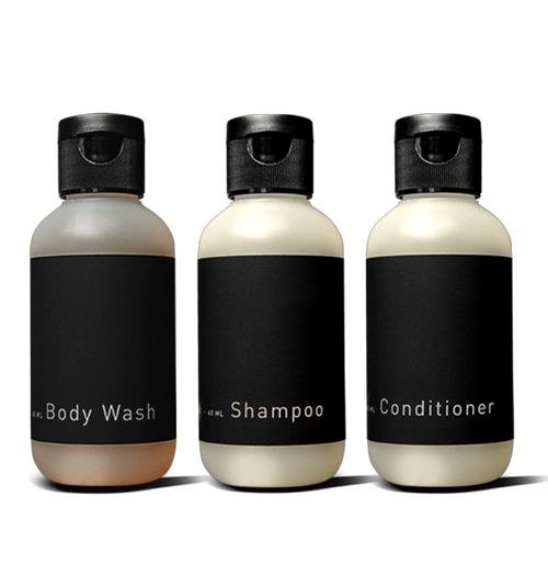 The Hawthorne Travel Shower Kit features three small black flip-top bottles—Body Wash, Shampoo, and Conditioner—displayed side by side against a black background.